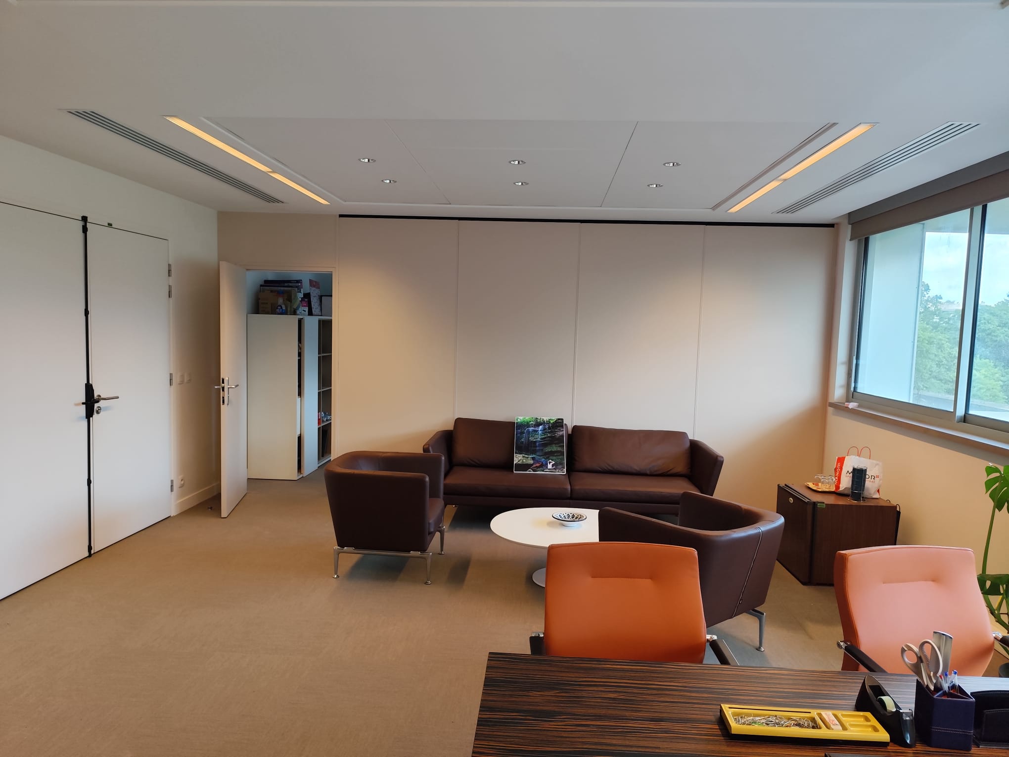 Intérieur d'un bureau moderne avec un canapé, des fauteuils et une table basse.