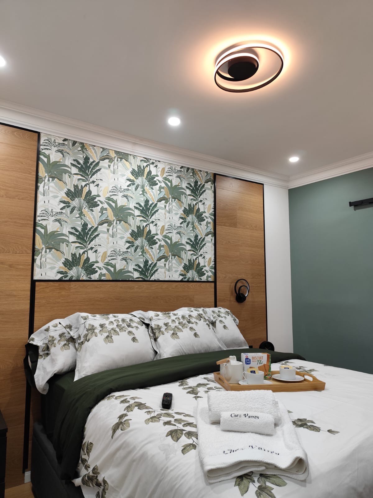 Chambre moderne avec mur décoratif végétal et lit confortable