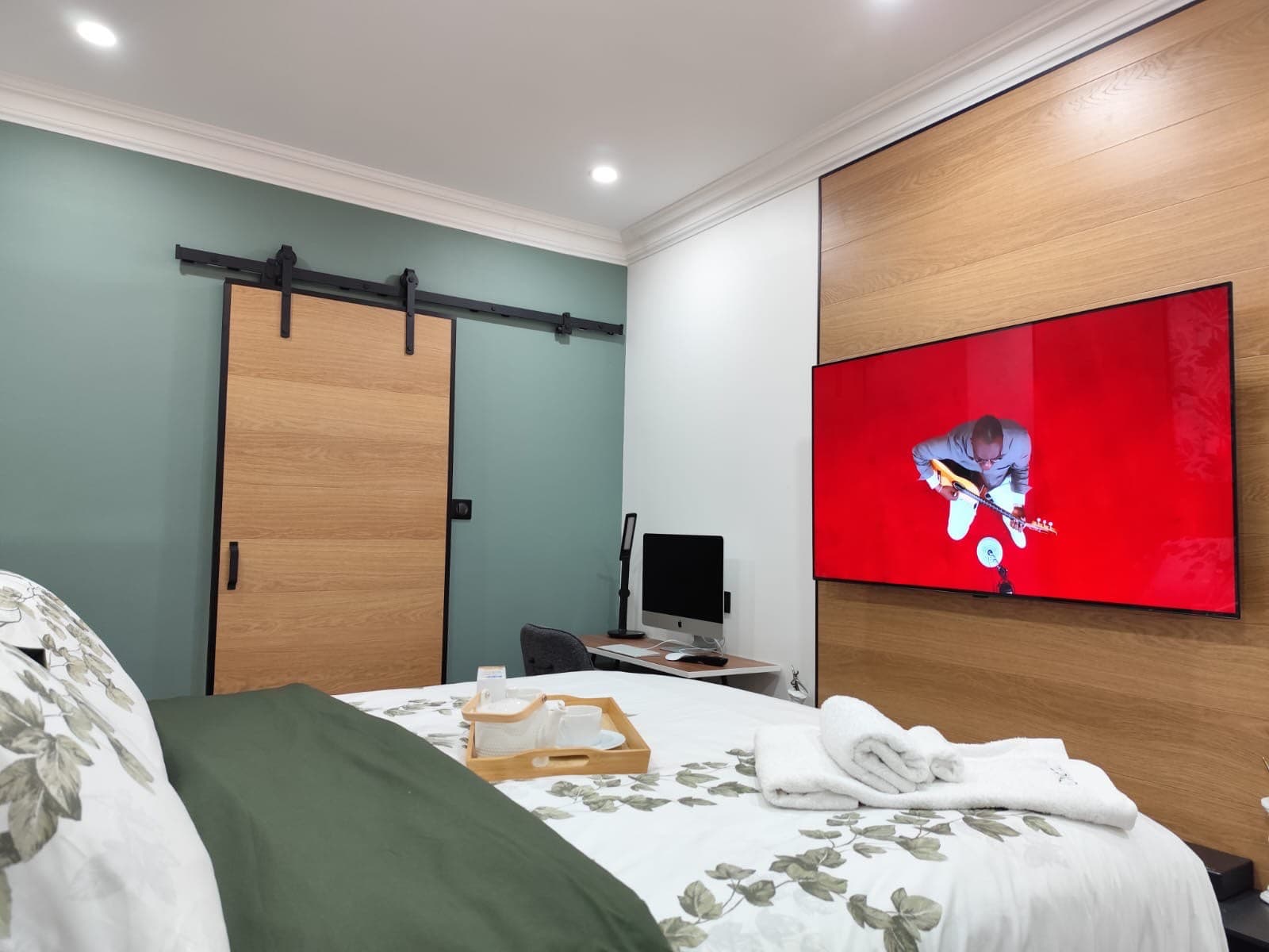 Chambre moderne avec mur en bois et télévision.