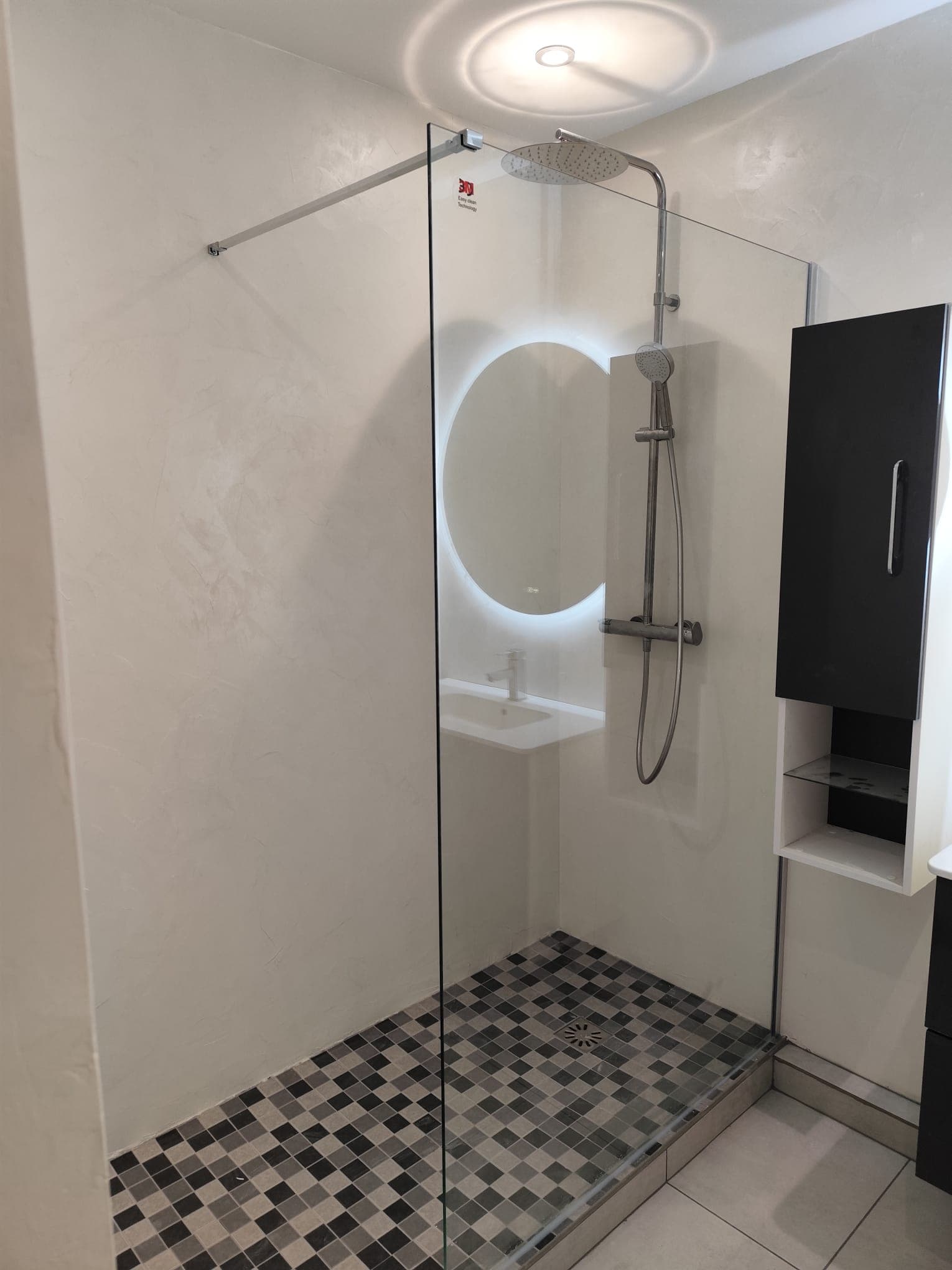 Miroir circulaire au-dessus d'un lavabo moderne dans une salle de bain