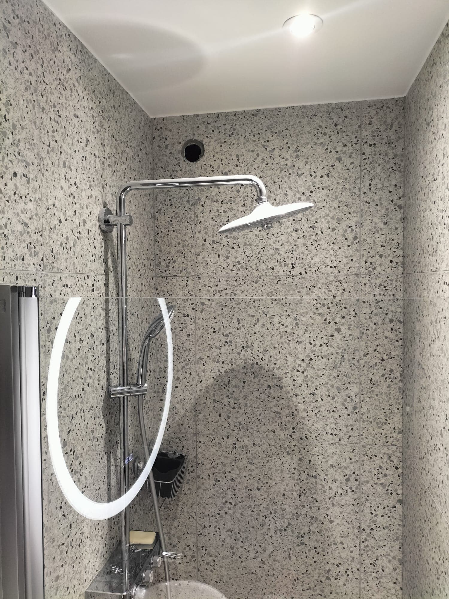 salle de bain avec meuble lavabo, étagères et miroir rond
