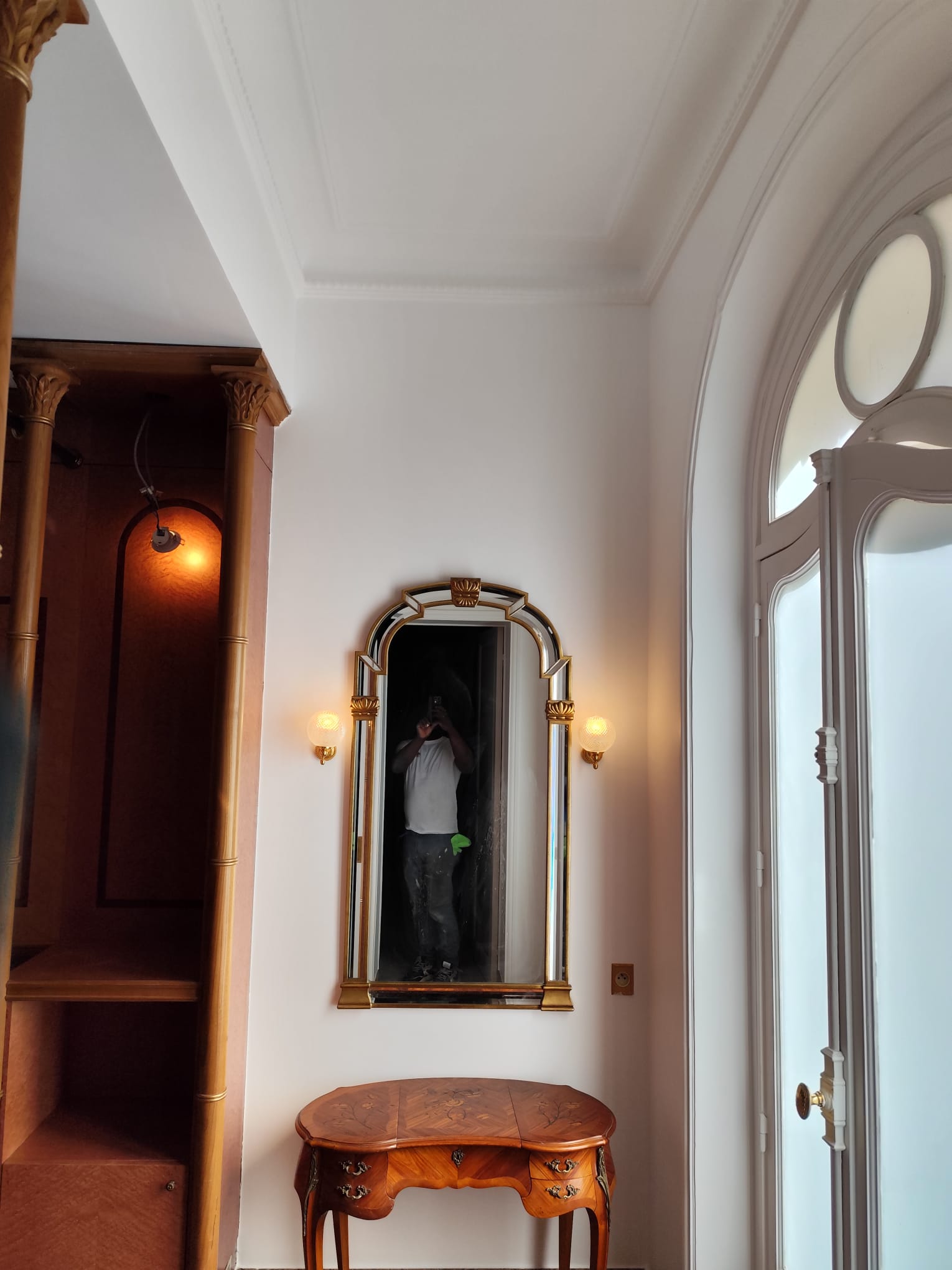 Intérieur avec un miroir décoratif et une console en bois