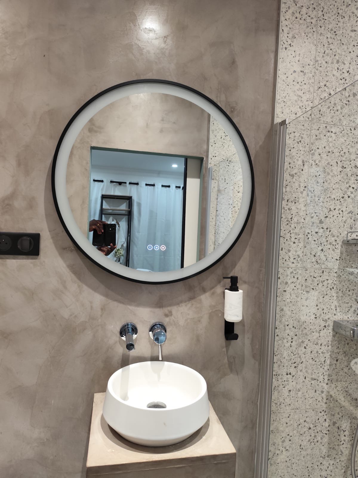 Miroir circulaire au-dessus d'un lavabo moderne dans une salle de bain