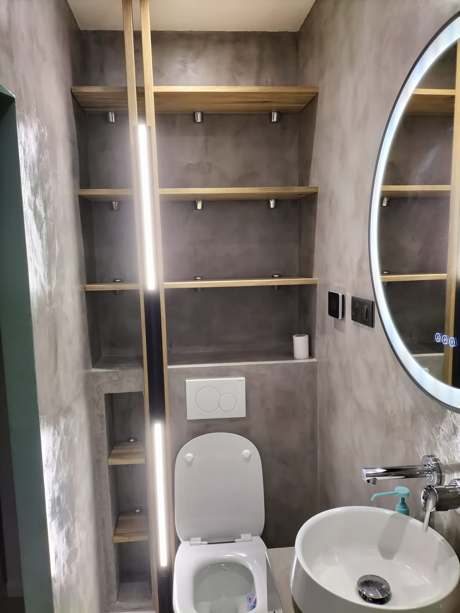 Salle de bain moderne avec miroir rond et éclairage intégré