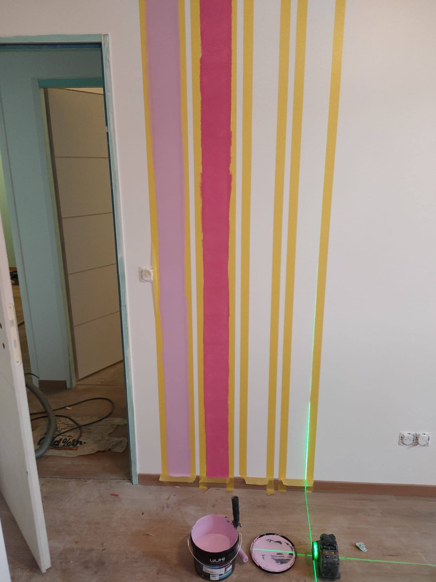 Travaux de peinture décorative : murs avec bandes de couleur et niveau laser